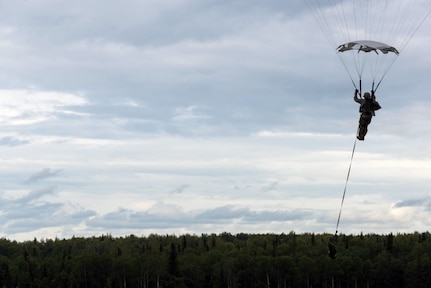 A U.S. Army paratrooper prepares to land after performing an airborne insertion from a C-130 Hercules during Red Flag-Alaska at Joint Base Elmendorf-Richardson, Alaska, Aug 10, 2016. Red Flag-Alaska is an exercise that provides joint offensive counter-air, interdiction, close air support and large force employment training in a simulated combat environment.