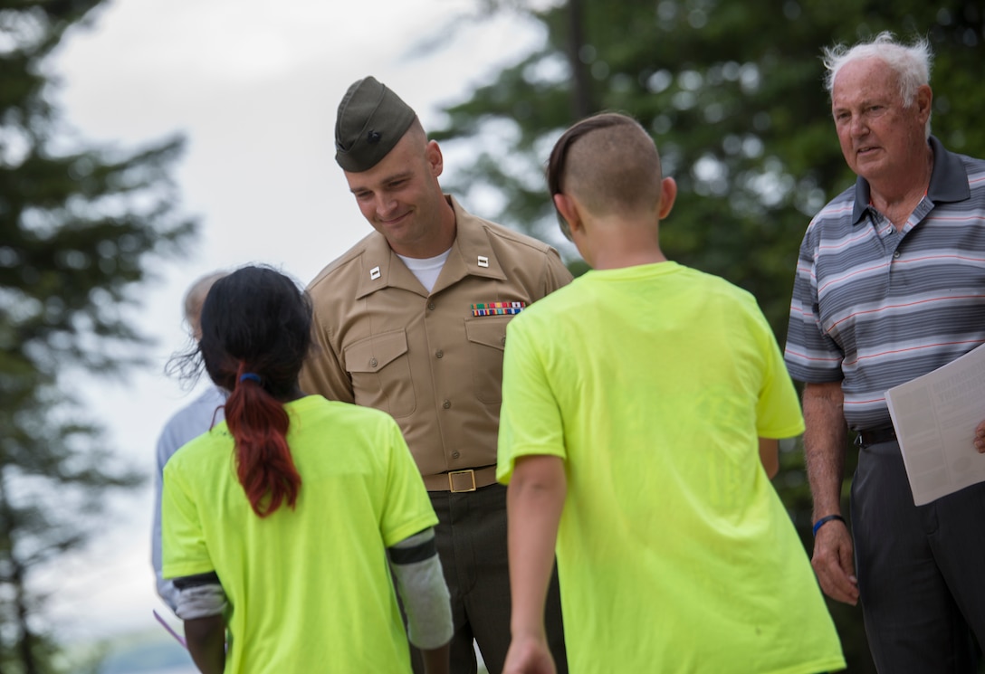 Capt. Brandon Bolhous, the officer in charge with 6th Engineer Support Battalion, 4th Marine Logistics Group, Marine Forces Reserve, receives thanks from children in the local community during the John H. Rich Jr. and Doris Lee Rich Memorial Beach and Ice Fishing Access Facility Dedication Ceremony in Standish, Maine, August 12, 2016. The Marines worked closely with the community to allow access to the beach and complete their annual Innovative Readiness Training. (U.S. Marine Corps photo by Sgt. Sara Graham) 