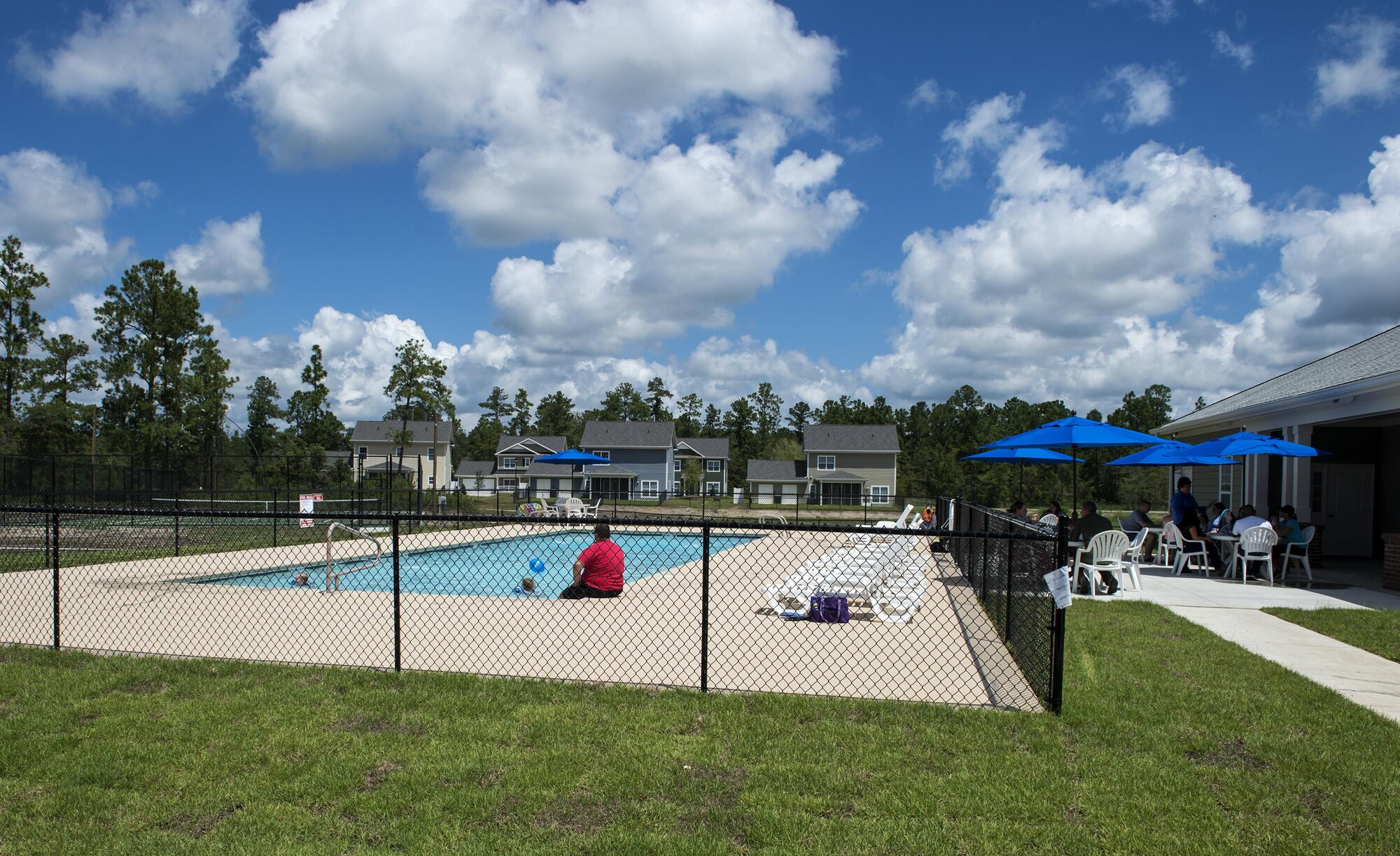 Residents eat barbeque and enjoy the pool during the grand opening of the community center in Azalea Commons, Aug. 12, 2016, in Valdosta, Ga. Azalea Commons houses 90 military families between E-1 and O-5. (U.S. Air Force photo by Airman 1st Class Janiqua P. Robinson)