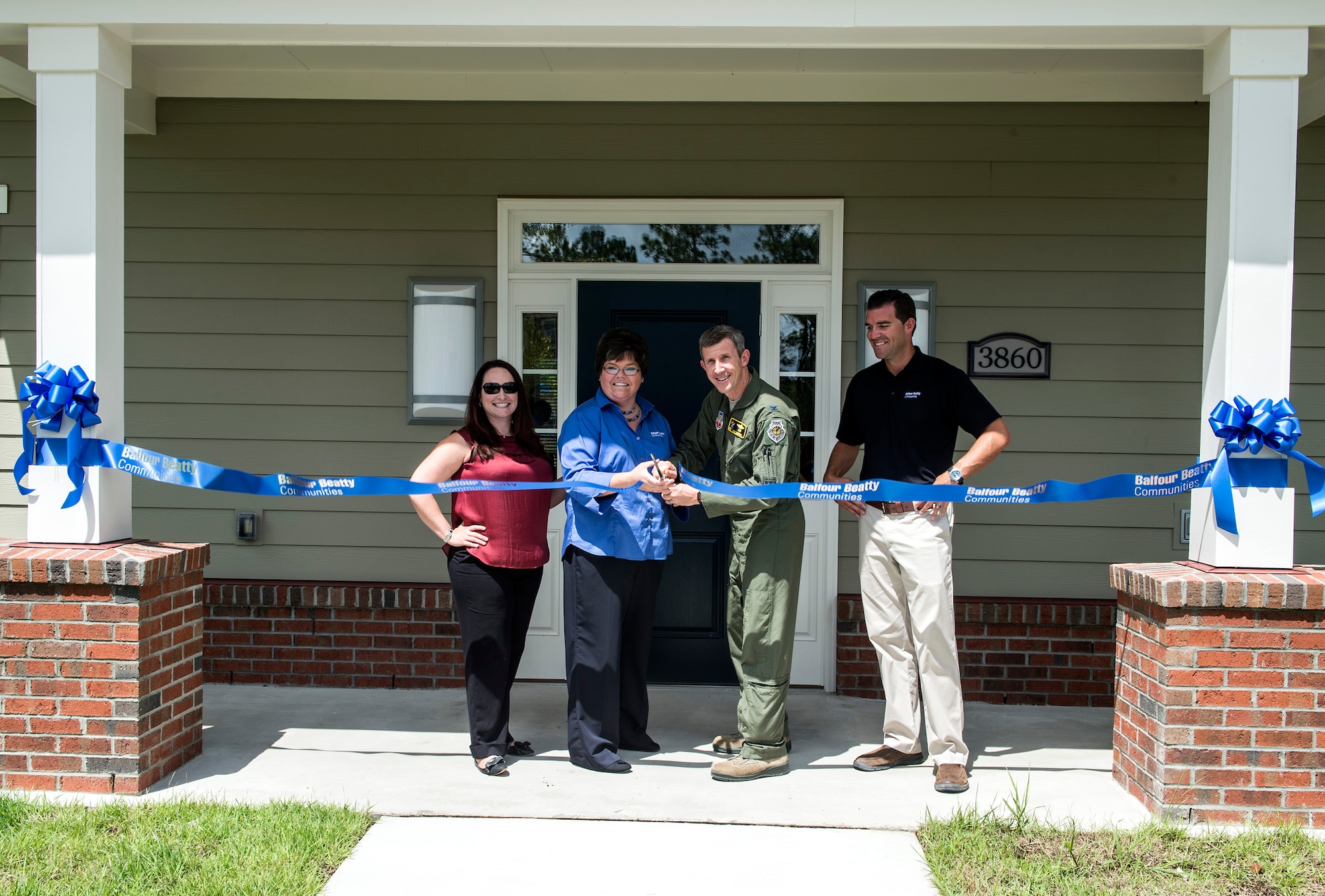 Devona Hathcock, center left, community manager for a local real estate company, and U.S. Air Force Col. Thomas Kunkel, center right, 23d Wing commander, cut a ribbon Aug. 12, 2016, in Valdosta, Ga. The ceremonial ribbon cutting celebrated the opening of the community center in the recently-opened Azalea Commons housing area. After the ceremonial ribbon cutting, attendees were served barbeque, toured the new community center and took a dip in the pool. (U.S. Air Force photo by Airman 1st Class Janiqua P. Robinson)