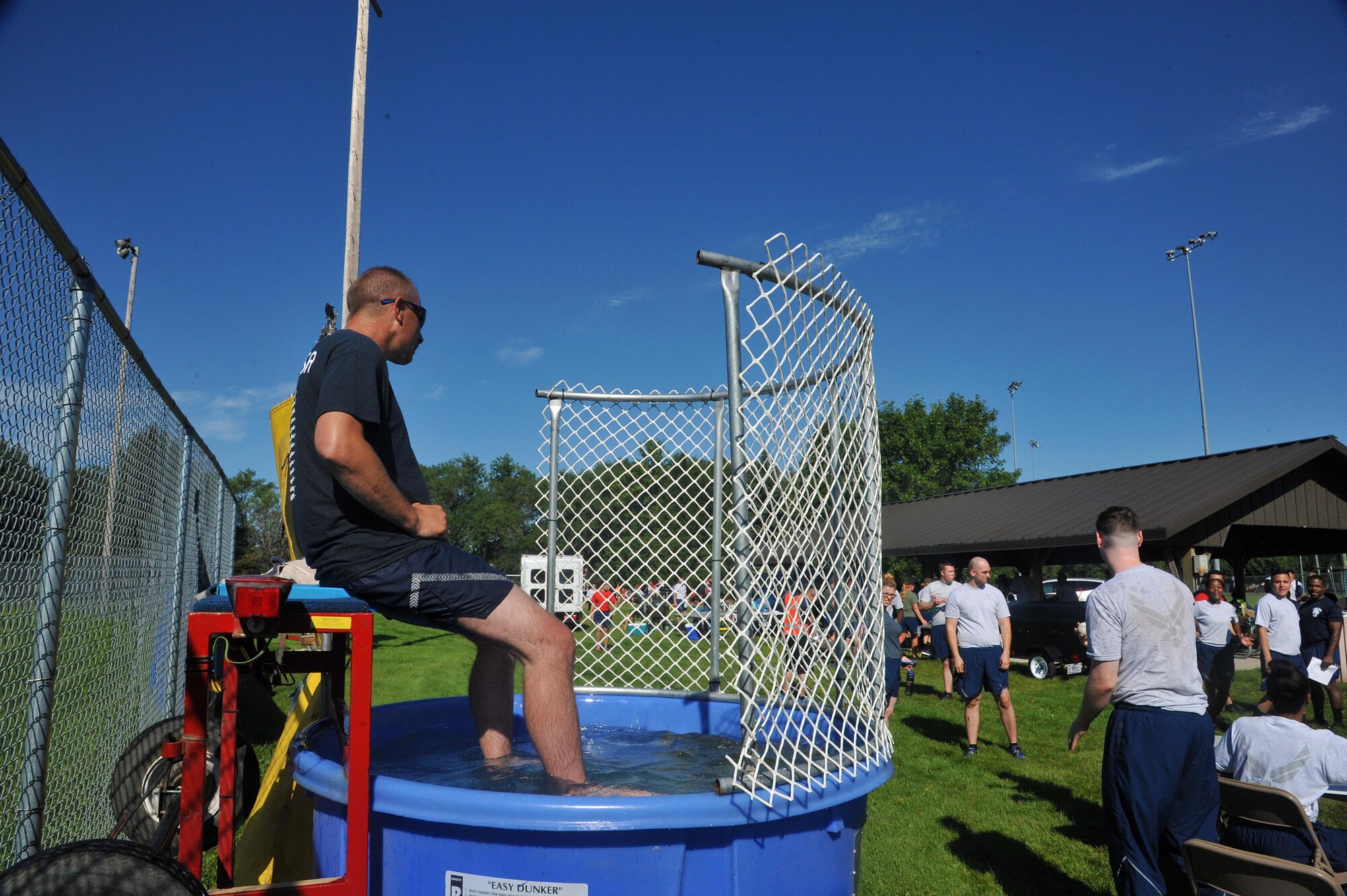 Master Sgt. Ronald Brooks, 319th Wing Staff Agencies’ first sergeant, mans the dunk tank at the 2016 Summer Bash, August 12 on Grand Forks Air Force Base, N.D. Airmen and family members threw balls at a target  in an attempt to submerge Brooks.  (U.S. Air Force Photo by Airman 1st Class Elijaih Tiggs/released)