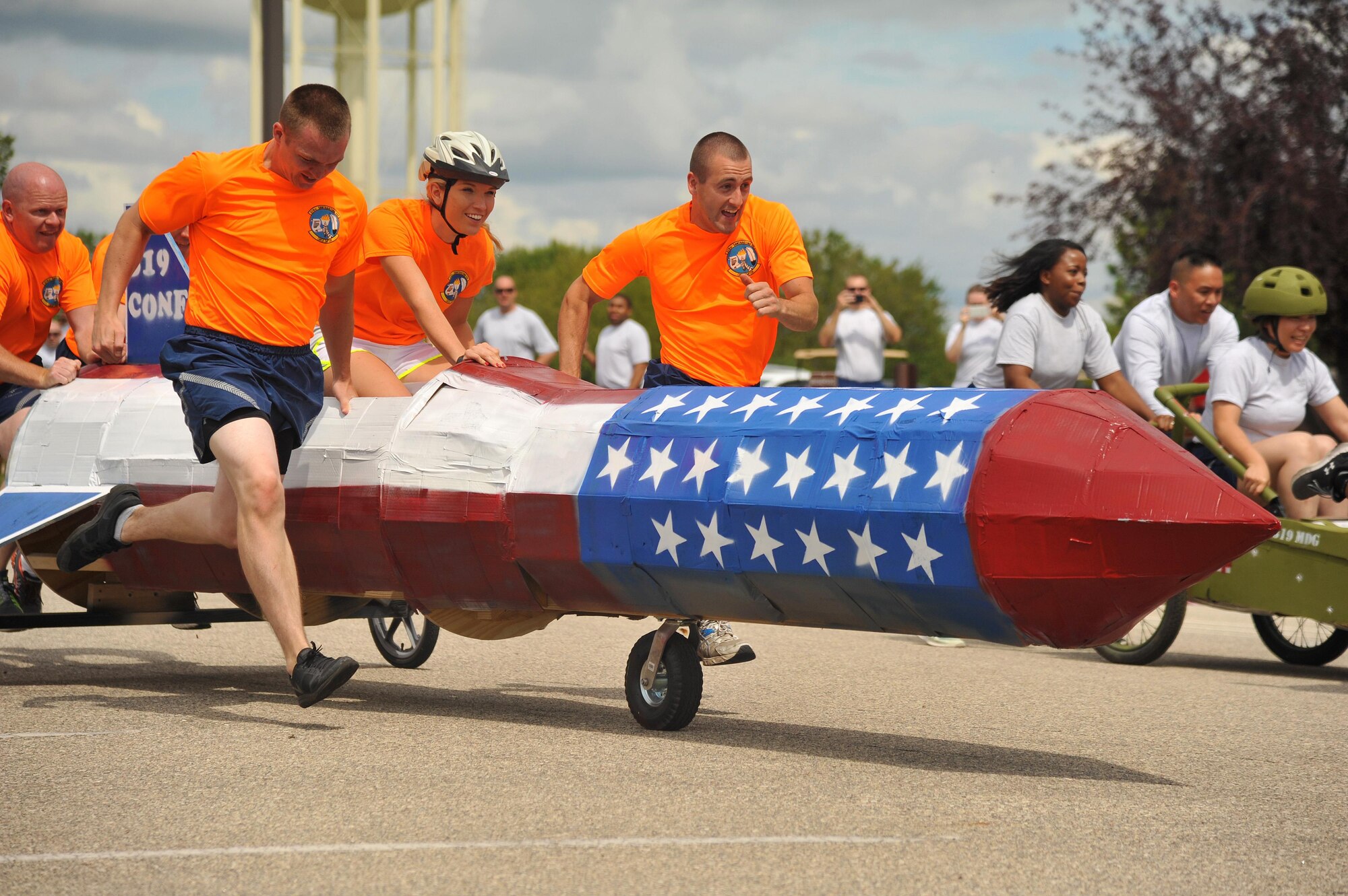 Airmen from the 319th Contracting Flight and 319th Medical Group  race against each other in the bed race event during Summer Bash 2016, August 12 on Grand Forks Air Force Base, N.D. Each team consisted of four pushers or pullers and one driver. The driver had to perform several tasks from end of the course in order to cross the finish line.  (U.S. Air Force Photo by Airman 1st Class Elijaih Tiggs/released)