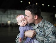 U.S. Air Force Staff Sgt. John Dunlap, a 35th Aircraft Maintenance Unit F-16 Fighting Falcon crew chief deployed from Kunsan Air Base, Republic of Korea, kisses his 6-month-old baby Evelyn after his shift Aug. 11, 2016, during RED FLAG-Alaska (RF-A) 16-3 at Eielson Air Force Base, Alaska. Dunlap’s family took the time he was in the U.S. to visit during RF-A, a Pacific Air Forces commander-directed exercise, which is vital to maintaining peace and stability in the Indo-Asia-Pacific area of responsibility. (U.S. Air Force photo by Staff Sgt. Shawn Nickel)