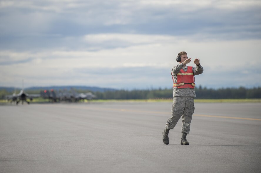 U.S. Air Force Airman 1st Class Nicholas Proia, an avionics technician assigned to the 4th Aircraft Maintenance Squadron from Seymour Johnson Air Force Base, N.C., marshals fighter jets through the test cell to ensure weapons and electronic warfare equipment operate properly prior to a sortie at Eielson Air Force Base, Alaska, Aug. 15, 2016, during RED FLAG-Alaska (RF-A) 16-3. RF-A provides realistic combat training essential to the success of air and space operations while providing unique opportunities to integrate various forces into joint, coalition and multilateral training from simulated forward operating bases. (U.S. Air Force photo by Staff Sgt. Shawn Nickel)