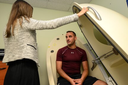 Staff Sgt. Zachary Woodard, 628th Comptroller Squadron (CPTS) deputy disbursing officer, right, listens to Alaine Mills, Health and Wellness Center (HAWC) nutrition’s program manager, left, as she instructs him on the use of the BodPod at Joint Base Charleston – Air Base, S.C., Aug. 11, 2016. The BodPod is a device used to inform a person of their body fat percentage. (U.S. Air Force photo by Airman 1st Class Thomas T. Charlton)