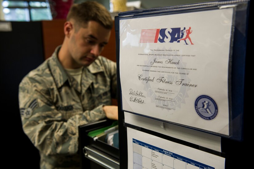 Senior Airman James Hauck, 628th Comptroller Squadron budget analyst, looks for documented information for an airman at Joint Base Charleston – Air Base, S.C., Aug. 9, 2016. Being a certified fitness trainer, Hauck is able to help his squadron with their health and wellness both in and out of the office. (U.S. Air Force photo by Airman 1st Class Thomas T. Charlton)