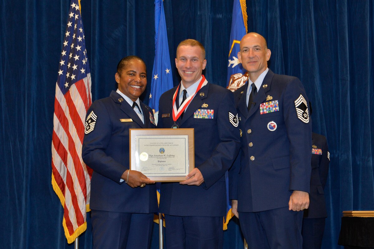 Tech. Sgt. Jonathan Leffring, right, receives the Distinguished Graduate Award for NCO academy class 16-5 from Chief Master Sgt. Shelina Frey, Command Chief Master Sgt. of Air Mobility Command, and Chief Master Sgt. Edward Walden, Sr., Commandant of the Paul H. Lankford Enlisted PME Center, here, Aug. 12, 2016, at the I.G. Brown Training and Education Center in Louisville, Tenn. The distinguished graduate award is presented to the top 10 percent of the class.   (U.S. Air National Guard photo by Master Sgt. Jerry D. Harlan/Released)