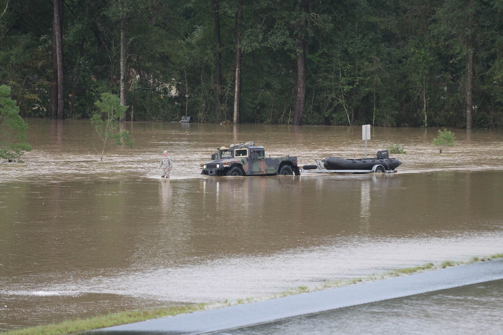 A Louisiana National Guardsman guiding a Humvee through floodwaters off of I-12 outside of Denham Springs. 