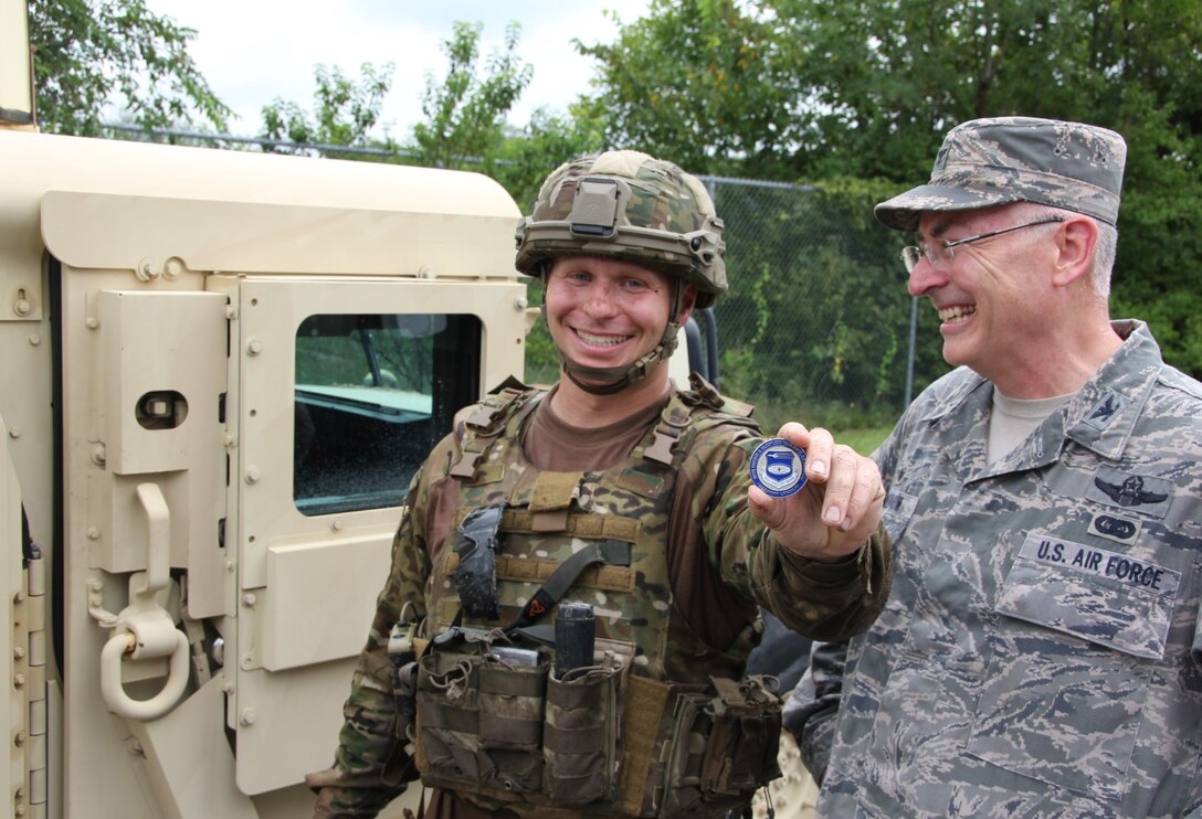 The 932nd Airlift Wing's Explosive Ordnance Disposal team member Staff Sgt. Kody Bloodworth, was recognized with a coin by the wing commander, Col. Jonathan Philebaum, for his outstanding work attitude and attention to detail, during a training event at Scott Air Force Base on August 13, 2016.  Airmen of the 932nd Civil Engineering Squadron battled the elements of rain, summer heat, humidity, thick mud, and bugs deep in the woods, but they managed their resources and kept squadron camaraderie high. (U.S. Air Force photo by Maj. Stan Paregien)