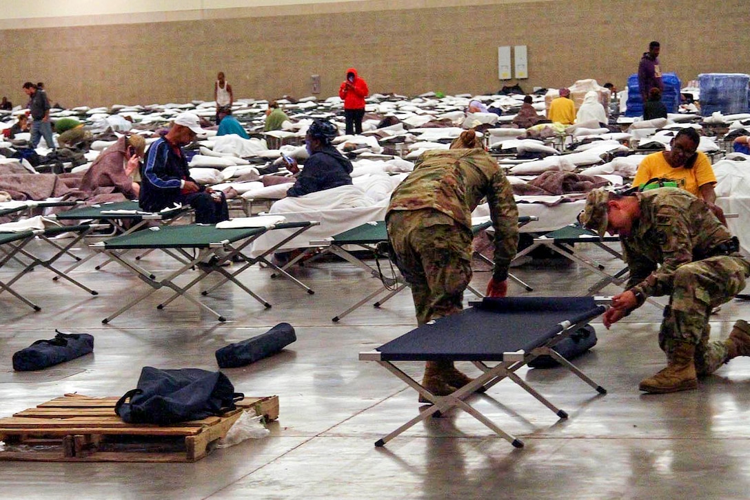 Soldiers set up cots for residents displaced by severe flooding in the Baton Rouge River Center in Baton Rouge, La., Aug. 15, 2016. The soldiers are assigned to the Louisiana National Guard's 2228th Military Police Company. Army National Guard photo by Spc. Garrett L. Dipuma