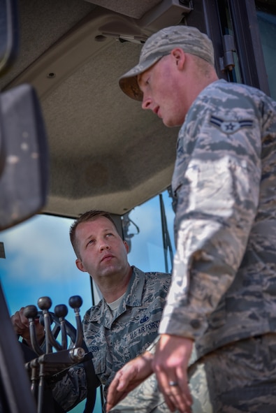 Chief Master Sgt. Edwin Ludwigsen, 52nd Fighter Wing command chief, receives instruction from Airman 1st Class Tyler Carrigan, 52nd Civil Engineer Squadron, on how to operate heavy equipment as part of an "out and about" visit with 52nd CES at Spangdahlem Air Base, Germany, Aug. 11, 2016. (U.S. Air Force photo by Tech. Sgt. Christopher Parr)