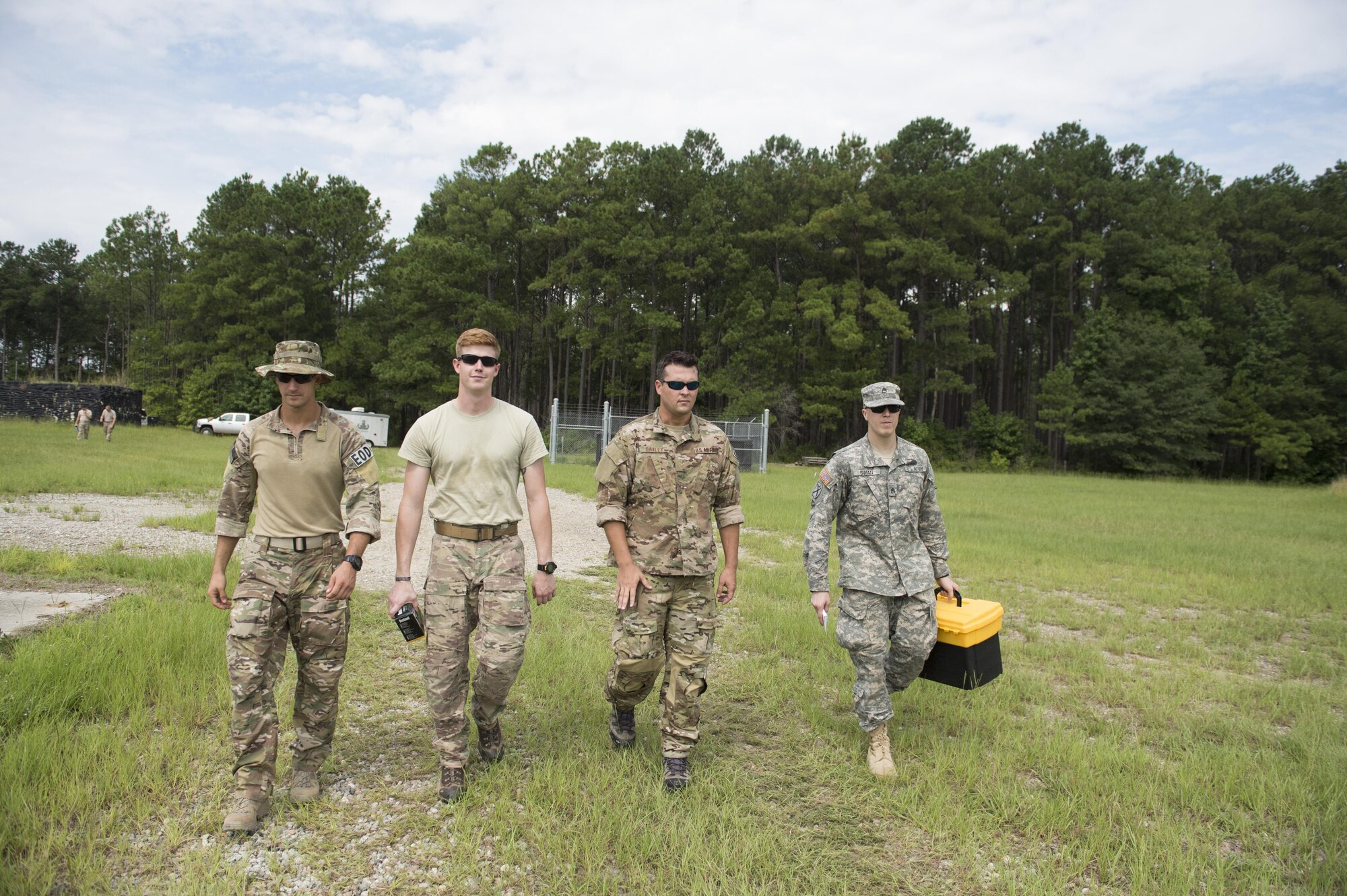 Airmen and a Soldier walk toward a controlled explosion site, Aug. 3, 2016 at Joint Base Charleston – Weapons Station, S.C. The joint post-blast analysis training exercise included 22 participants from the Kentucky Air National Guard, South Carolina Air National Guard, Army South Carolina Guard, MacDill Air Force Base, Fla. Seymour Johnson Air Force Base, N.C., 628th Civil Engineering Squadron and 315th CEF. The trainees honed their skills of collecting evidence after an IED attack. (U.S. Air Force photo/Staff Sgt. Jared Trimarchi)