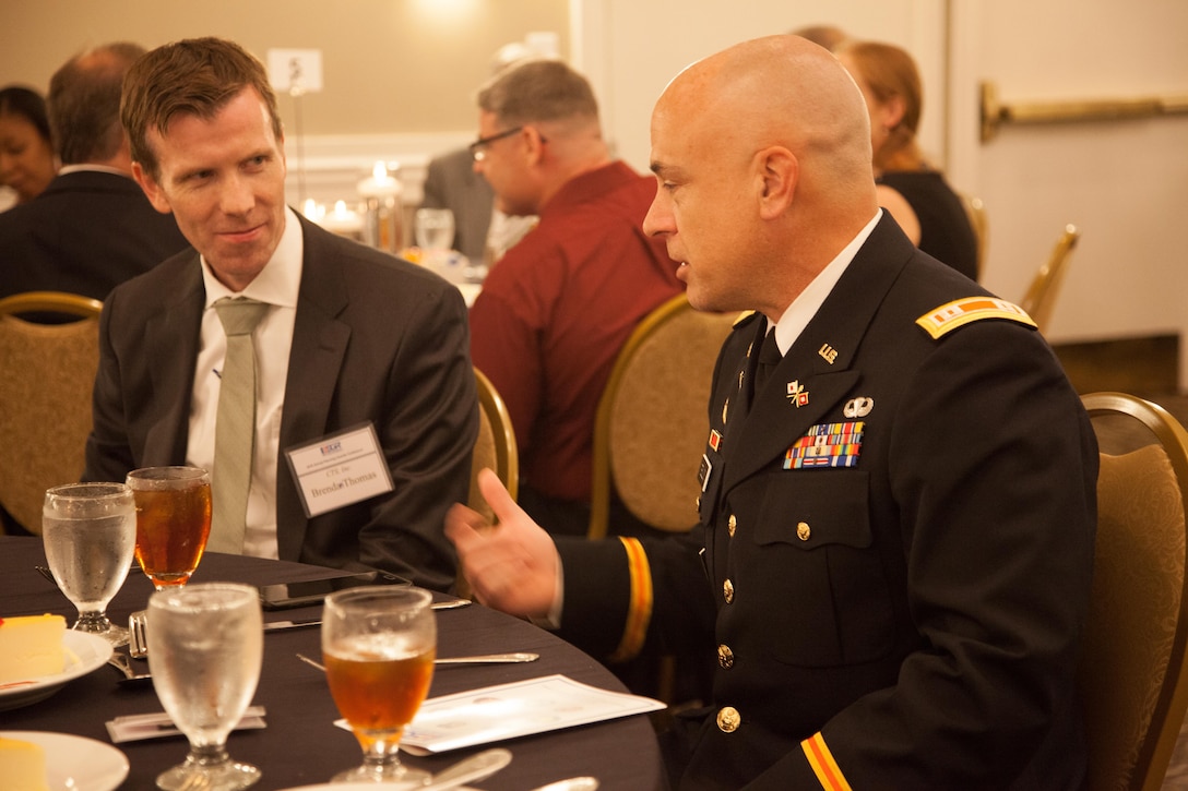 U.S. Army Reserve Capt. Spencer Teillon (Right), a Soldier assigned to 982nd Combat Camera Company (Airborne) and also Architect of Computer Technology Solutions (CTS) Incorporation, and Brendan Thomas (Left), President of CTS Inc., discusses the difference between their software company and other companies at the Wyndham Peachtree Hotel and Conference Center during the annual Georgia Employer Support of the Guard and Reserve (ESGR) banquet in Peachtree City, Georgia, Aug. 12, 2016. (U.S. Army Reserve photo by Pfc. Torrance Saunders/Released)