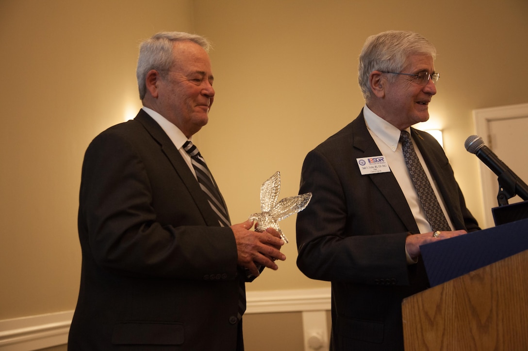 Retired U.S. Army Reserve Lt. Gen. James Helmly (Left) holds an awarded he received at the Wyndham Peachtree Hotel and Conference Center during the Employer Support of the Guard and Reserve (ESGR) banquet in Peachtree City, Georgia, Aug. 12, 2016. ESGR is a Department of Defense volunteer organization established in 1972 to promote cooperation and understanding between Reserve component members and their civilian employers and to assist in the resolution of conflicts arising from an employee's military commitment. (U.S. Army Reserve photo by Pfc. Torrance Saunders/Released)