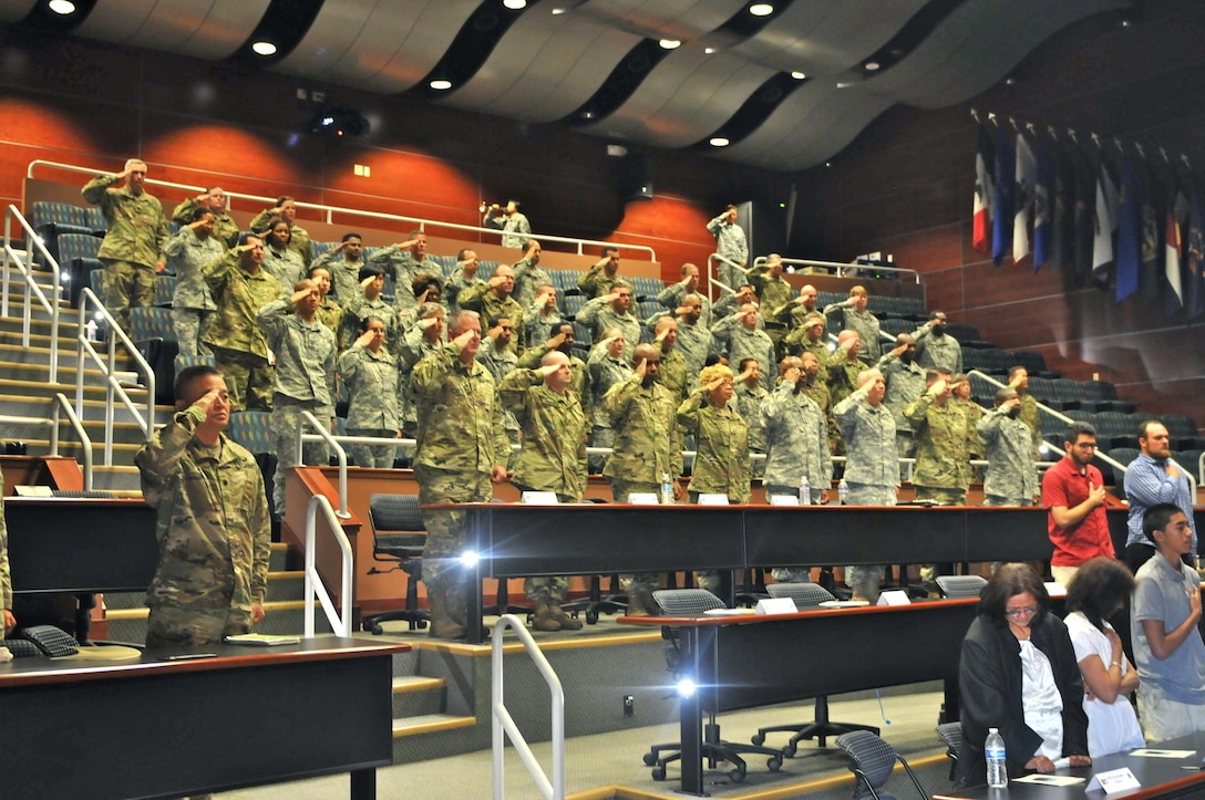 Soldiers from the 63rd Regional Support Command, family and friends of Capt. Joel Ico, stand and pay one final tribute as ‘Taps’ plays at the conclusion of a memorial service for Ico, Aug. 14, headquarters auditorium, Mountain View, Calif. Ico died July 4 at the age of 41, following an accident at his residence. He is survived by his wife Michelle and 7 children.(U.S. Army Reserve photo by Capt. Alun Thomas)