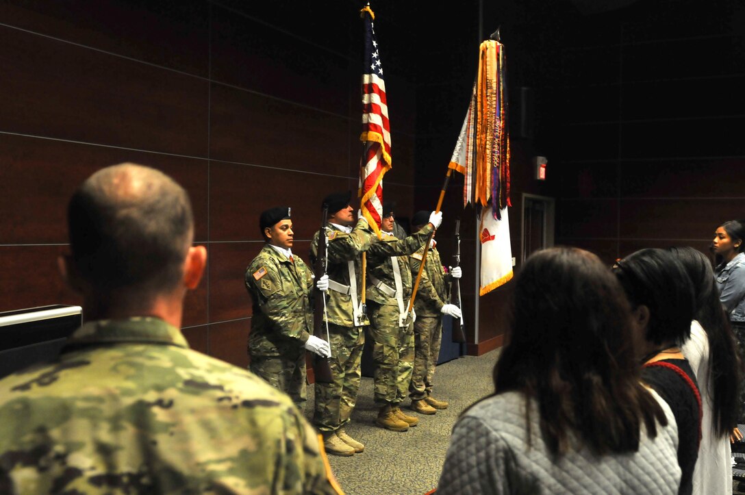 Watched by Maj. Gaetano Simeti (left), plans officer, 63rd Regional Support Command, and Michelle Ico (right), the 63rd RSC Honor Guard performs the placing of the colors, before a memorial ceremony for Capt. Joel Ico, Aug. 14, headquarters auditorium, Mountain View, Calif. (U.S. Army Reserve photo by Capt. Alun Thomas)