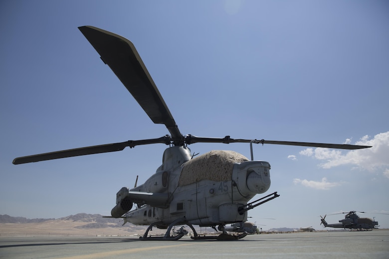 A Bell AH-1Z helicopter with Marine Corps Base Camp Pendleton, Calif.-based Marine Light Attack Helicopter Squadron 169 sits idle on the flight deck aboard Marine Corps Air Ground Combat Center, Twentynine Palms, Calif., with a canopy cover, Aug. 5, 2016. The covers were constructed by Staff Sgt. Daniel Plyler, flight equipment technician, HMLA-169, to reduce the effects of heat on the aircraft and the Marines who operate it. (Official Marine Corps photo by Cpl. Medina Ayala-Lo/Released)
