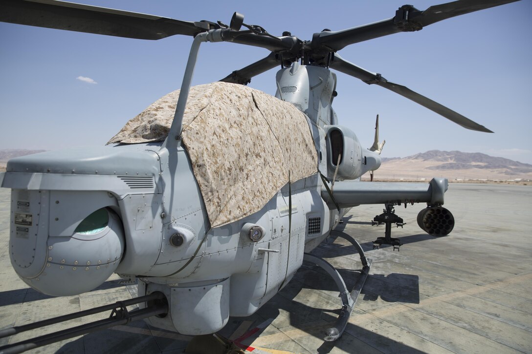 A Bell AH-1Z helicopter with Marine Corps Base Camp Pendleton, Calif.-based Marine Light Attack Helicopter Squadron 169 sits idle on the flight deck aboard Marine Corps Air Ground Combat Center, Twentynine Palms, Calif., with a canopy cover, Aug. 5, 2016. The covers were constructed by Staff Sgt. Daniel Plyler, flight equipment technician, HMLA-169, to reduce the effects of heat on the aircraft and the Marines who operate it. (Official Marine Corps photo by Cpl. Medina Ayala-Lo/Released)