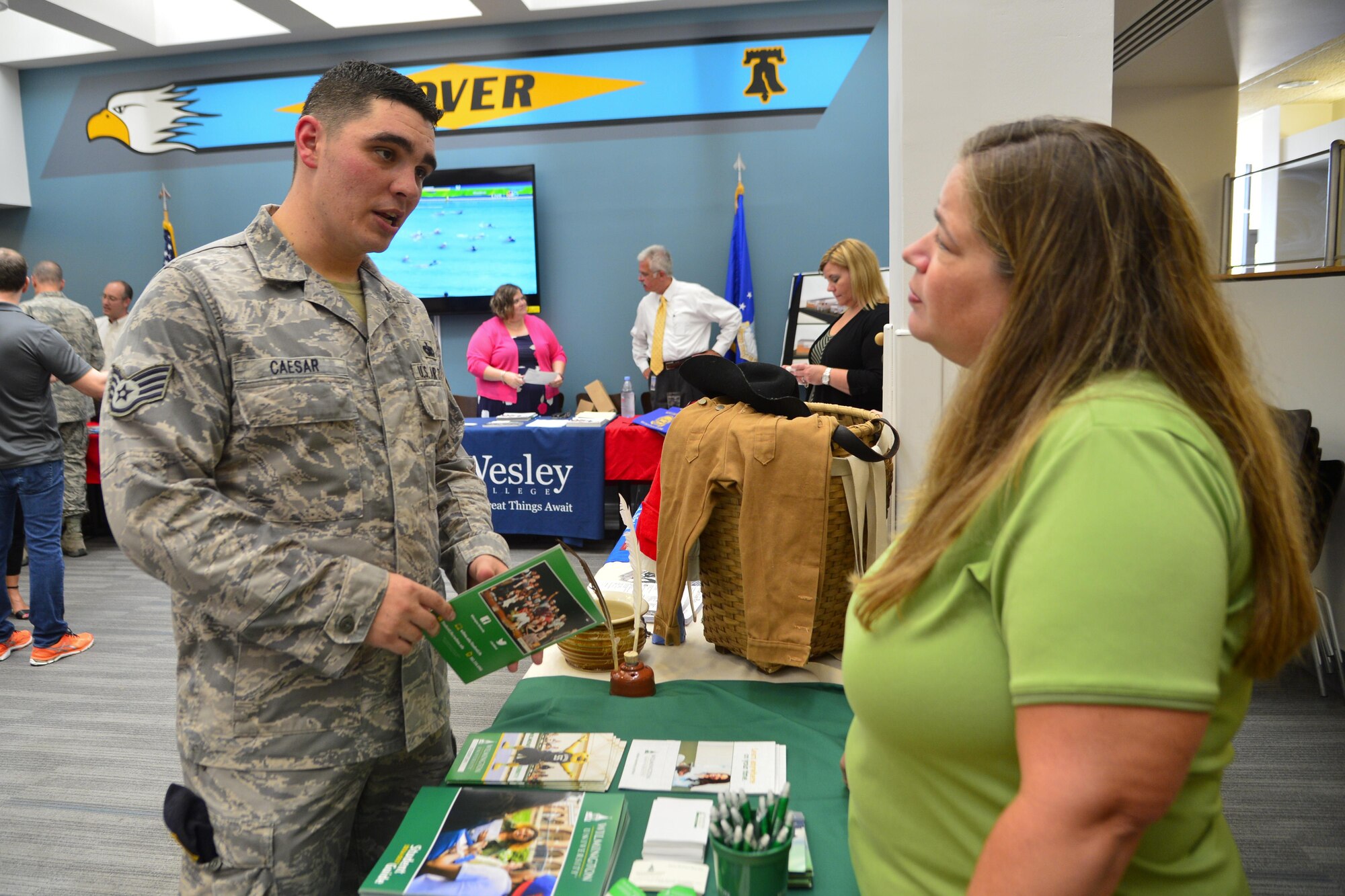 Staff Sgt. Russell Caesar, 314th Recruiting Squadron recruiter, receives an educational brochure from Wilmington University at the first ‘Dover Welcomes You’ session Aug. 11, 2016, at the Patterson Dining Facility on Dover Air Force Base, Del. Dover Welcomes You sessions are held the second Thursday of each month with the next session scheduled for Sept. 8, 2016, at the Fitness Center. (U.S. Air Force photo by Senior Airman William Johnson)