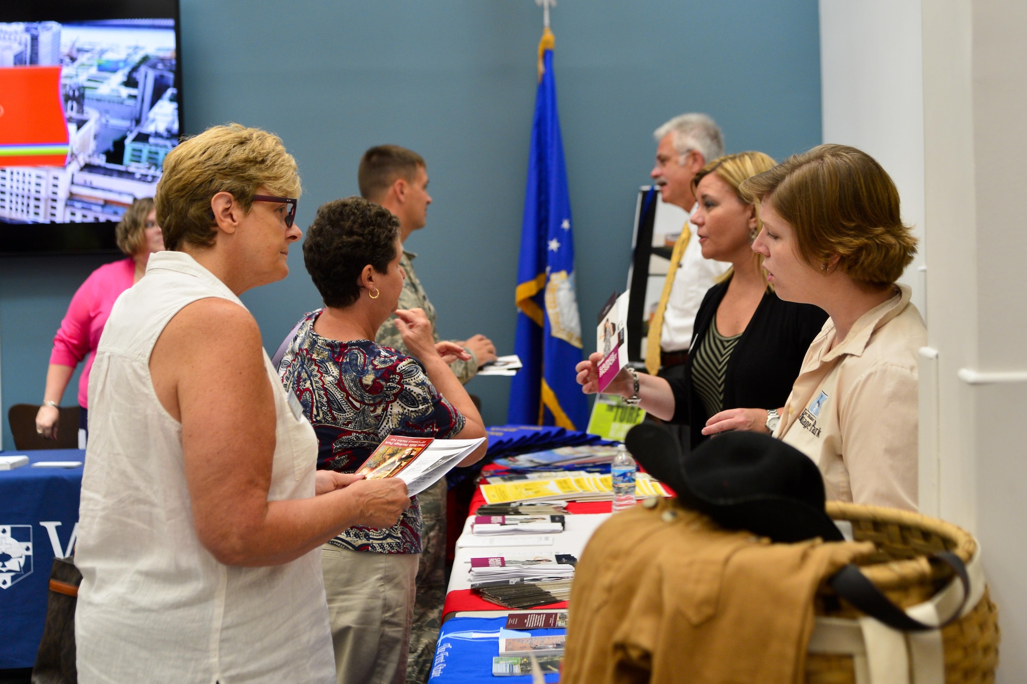 Attendees of the first ‘Dover Welcomes You’ session receive informational brochures and other handouts from the local Dover community Aug. 11, 2016, at the Patterson Dining Facility on Dover Air Force Base, Del. These sessions are to inform Team Dover Airmen of upcoming local events, site attractions and other family activities that Dover has to offer. (U.S. Air Force photo by Senior Airman William Johnson)