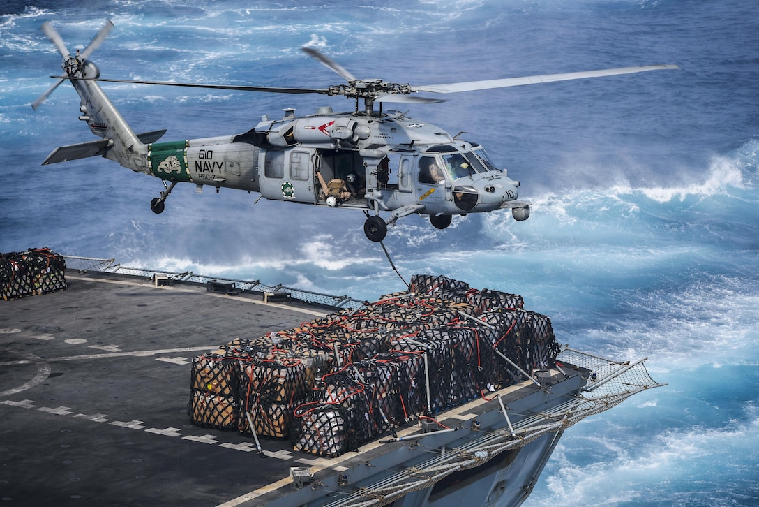 An MH-60S Seahawk helicopter prepares to deliver cargo to the flight deck of the aircraft carrier USS Dwight D. Eisenhower during a replenishment with the fast-combat support ship USNS Arctic in the Arabian Gulf, Aug. 12, 2016. The Eisenhower is supporting Operation Inherent Resolve, maritime security operations and theater security cooperation efforts in the U.S. 5th Fleet area of operations. Navy photo by Seaman Christopher Michaels