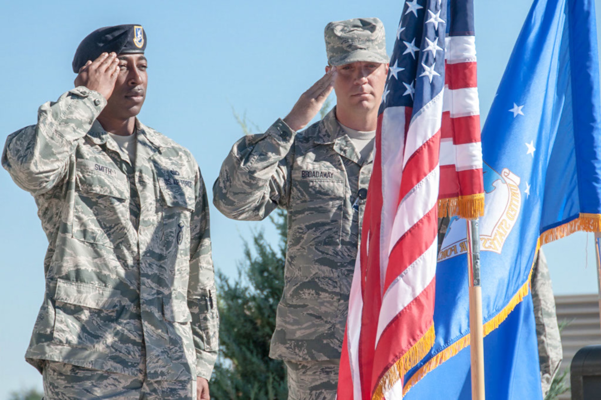 Master Sgt. Broadaway and Tech. Sgt. Smith salute the flag during the opening ceremony to celebrate the moving of the MSG to the 310th SW Headquarters on 7 Aug. 2016.