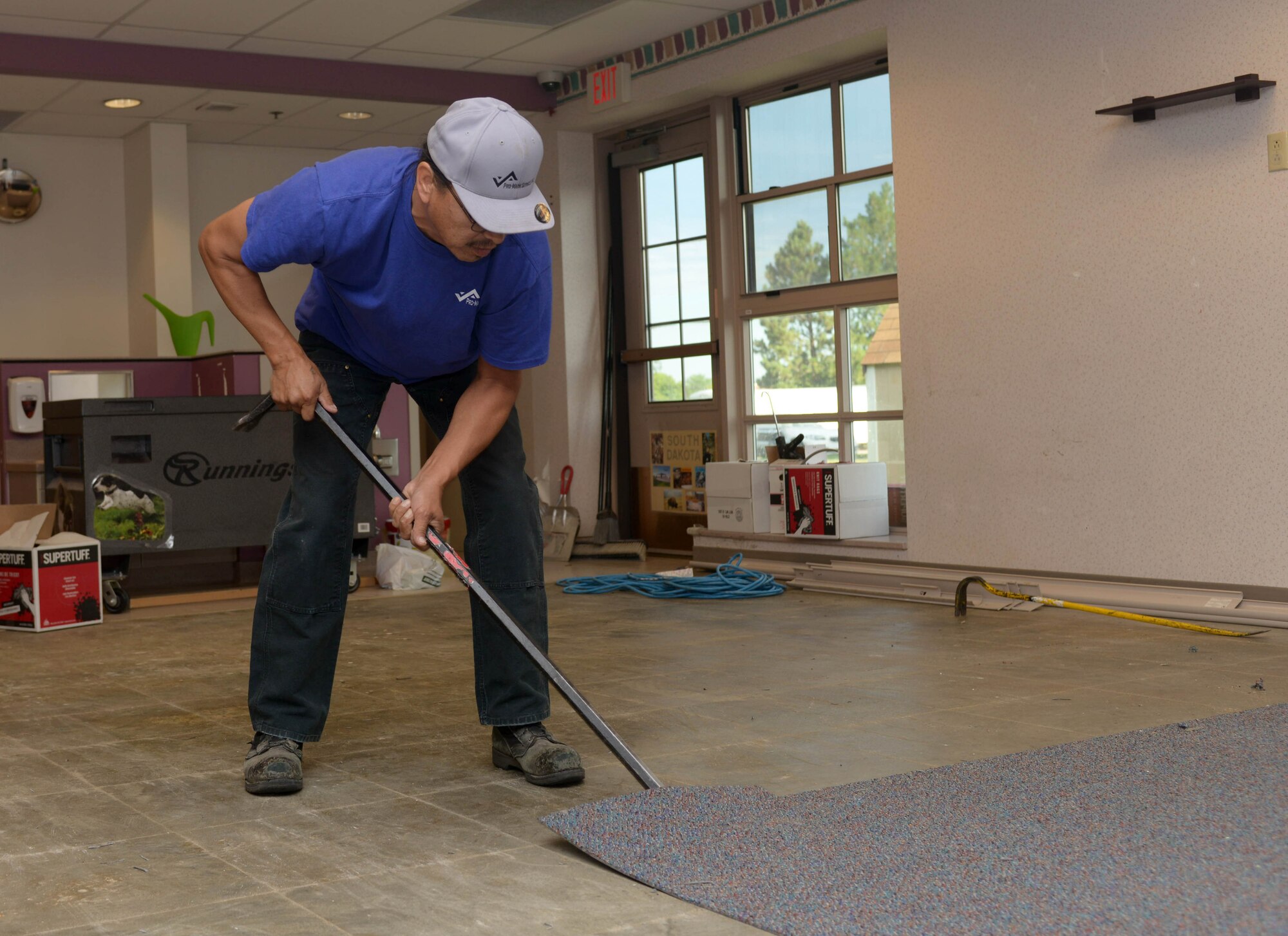 Marty Tobacco, a Pro-Mark laborer, removes carpet from the Child Development Center at Ellsworth Air Force Base, S.D., Aug. 16, 2016. The CDC is undergoing renovations, getting new wallpaper, a fresh coat of paint and new carpet. (U.S. Air Force photo by Airman 1st Class Donald Knechtel) 