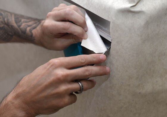 Mark Outka, a Berendse and Sons Painting job foreman, cuts new wall paper at the Child Development Center at Ellsworth Air Force Base, S.D., Aug. 16, 2016. After fitting the new wallpaper the excess paper is removed and used for a new spot on the wall. (U.S. Air Force photo by Airman 1st Class Donald Knechtel) 