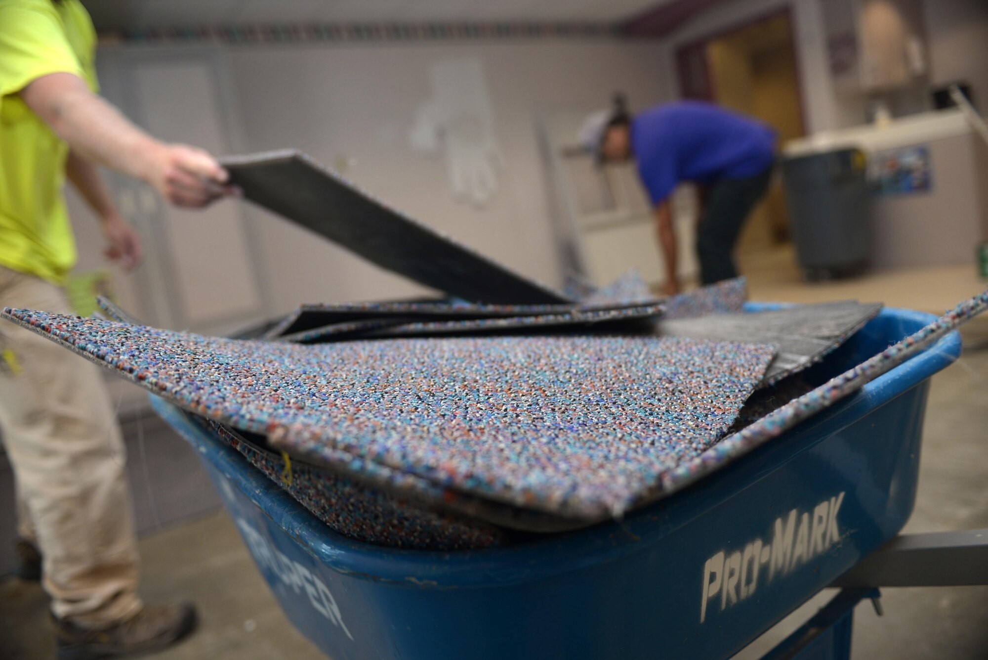 DJ Dunn and Marty Tobacco, Pro-Mark renovators, pile up old carpet tiles at the Child Development Center at Ellsworth Air Force Base, S.D., Aug. 16, 2016. The CDC provides quality child care service to Ellsworth to enable team members to meet mission requirements worldwide with the knowledge that their children are in a safe, healthy environment that fosters individual development through independent and creative exploration of their world. (U.S. Air Force photo by Airman 1st Class Donald Knechtel) 