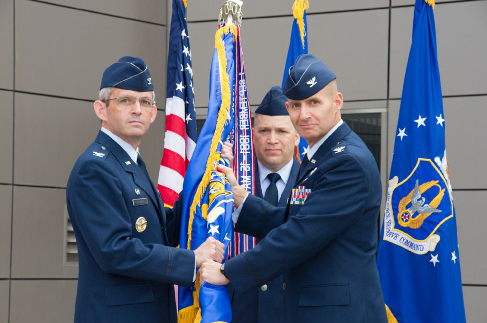 Colonel Assid passes the guidon to Colonel Feltman as he relinquishes command of the 310th Operations Group to Colonel Slade at a change of command ceremony on Schriever Air Force Base, Colorado, Sunday, Aug. 7, 2016