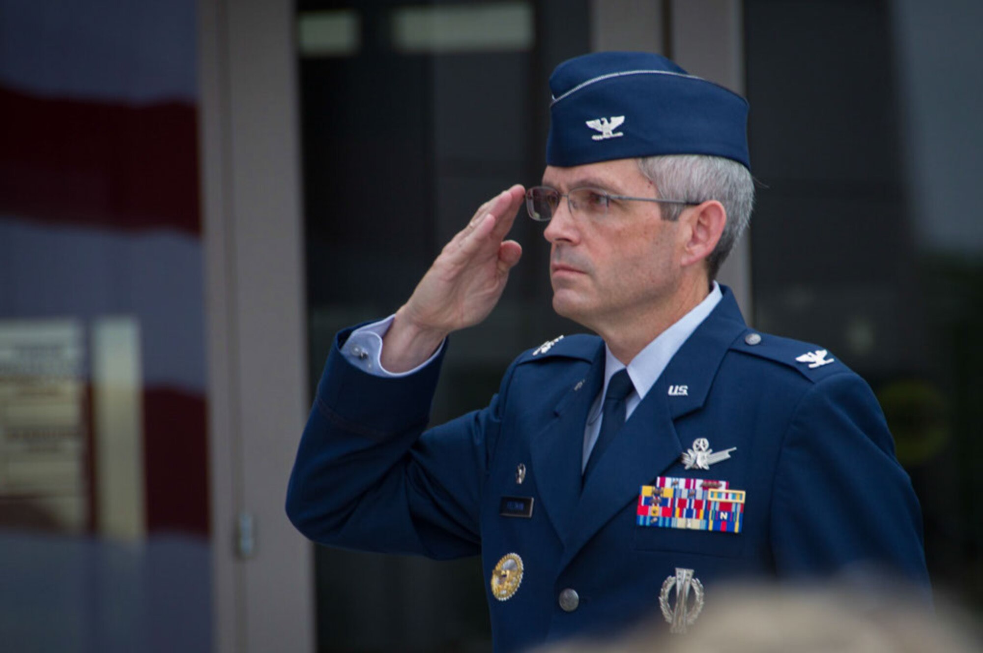 Colonel Feltman salutes the US flag during the 310th Operations Group change of command ceremony on Schriever Air Force Base, Colorado, Sunday, Aug. 7, 2016