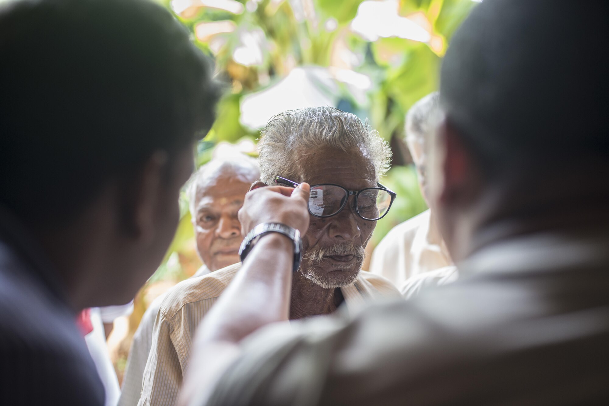 Both U.S. and Sri Lankan Air Force members test a pair of glasses on a Sri Lankan local national during Pacific Angel (PACANGEL) 16-3, Aug. 15, 2016. Assistance during PACANGEL includes general health, dental, optometry, physical therapy and engineering programs as well as various subject-matter expert exchanges. (U.S. Air Force photo by Senior Airman Brittany A. Chase)