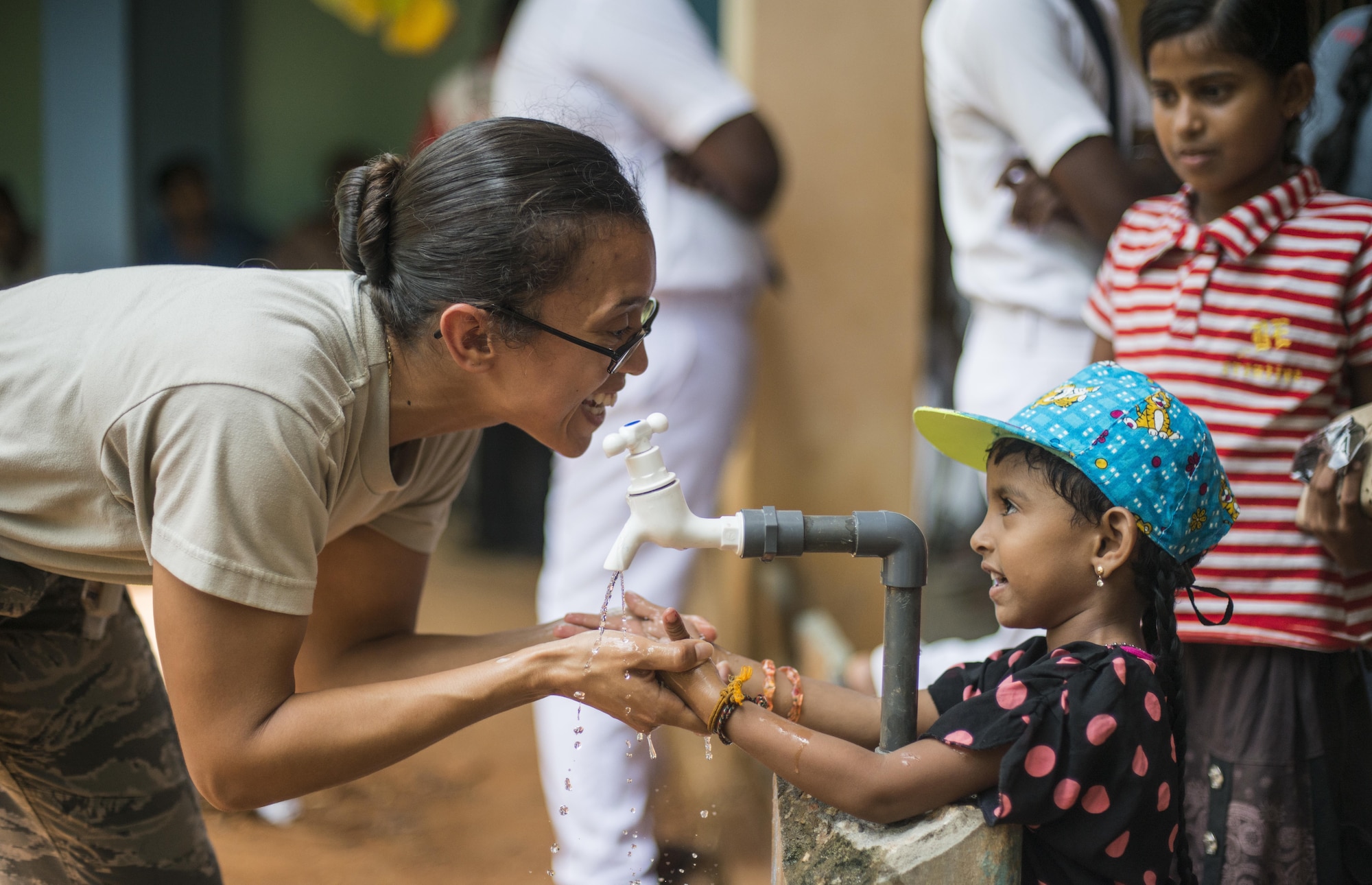U.S. Air Force Staff Sgt. Yesenia Benjamin, 18th Medical Group public health technician, teaches a Sri Lankan child how to properly wash her hands during Pacific Angel (PACANGEL) 16-3 in Jaffna, Sri Lanka, Aug. 16, 2016. Now entering its ninth year, Operation PACANGEL ensures that the region’s militaries are prepared to work together to address humanitarian crises. Since 2007, PACANGEL operations have improved the lives of tens of thousands of people. (U.S. Air Force photo by Senior Airman Brittany A. Chase)