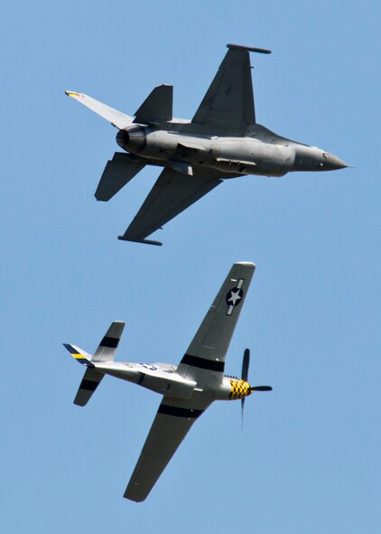 An F-16 Fighting Falcon (top) and a P-51D Mustang soar above the crowd during the Northern Neighbors Day Air Show at Minot Air Force Base, N.D., Aug. 13, 2016. The Heritage Flight showcased WWII aircraft with modern aircraft during NND. (U.S. Air Force photo/Airman 1st Class J.T. Armstrong)