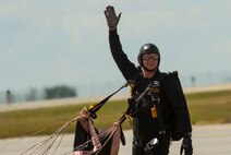 A member of the U.S. Army Golden Knights parachute team waves to the crowd after his landing during Northern Neighbors Day at Minot Air Force Base, N.D., Aug. 13, 2016. The Golden Knights were  thea featured performance at the air show. (U.S. Air Force photo/Senior Airman Apryl Hall)
