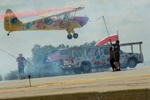 Kent Pietsch lands his aircraft on a truck during Northern Neighbors Day at Minot Air Force Base, N.D., Aug. 13, 2016. The Pietsch brothers flew several different aircraft in different demonstrations throughout the day. (U.S. Air Force photo/Senior Airman Apryl Hall)