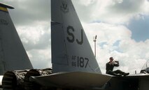 An Airman rests on an F-15E Strike Eagle from Seymour Johnson Air Force Base, N.C., while taking pictures during the Northern Neighbors Day Air Show at Minot AFB, N.D., Aug. 13, 2016. The air show featured several military aircraft from bases around the country. (U.S. Air Force photo/Senior Airman Sahara L. Fales)