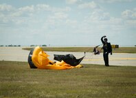 A member of the U.S. Army Golden Knights aerial demonstration team waves to the crowd after landing at Minot Air Force Base, N.D., during the Northern Neighbors Day Air Show on Aug. 13, 2016. The Golden Knights perform around the world at air shows, sports games and other performances. (U.S. Air Force photo/Senior Airman Sahara L. Fales)