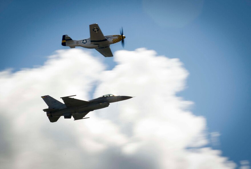 A P-51D Mustang and F-16 Fighting Falcon perform a Heritage Flight during the Northern Neighbors Day Air Show at Minot Air Force Base, N.D., Aug. 13, 2016. The two aircraft flew together to showcase how our aircraft has evolved. (U.S. Air Force photo/Senior Airman Sahara L. Fales)