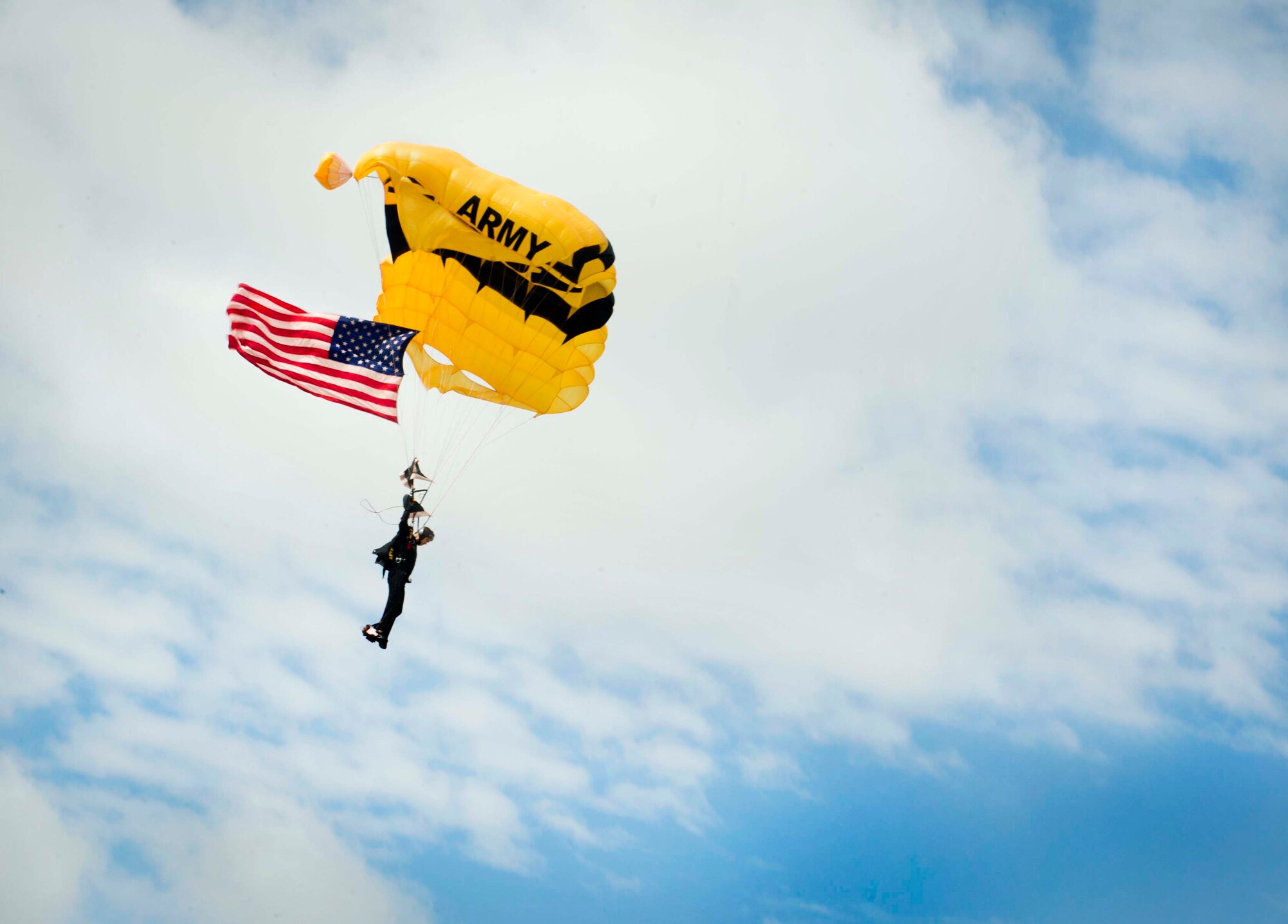 A member of the U.S. Army Golden Knights aerial demonstration team opens his parachute while landing at Minot Air Force Base, N.D., during the Northern Neighbors Day Air Show on Aug. 13, 2016. The Golden Knights demonstrated a variety of jumps during the air show. (U.S. Air Force photo/Senior Airman Sahara L. Fales)