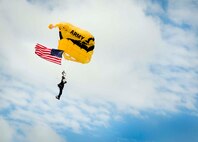 A member of the U.S. Army Golden Knights aerial demonstration team opens his parachute while landing at Minot Air Force Base, N.D., during the Northern Neighbors Day Air Show on Aug. 13, 2016. The Golden Knights demonstrated a variety of jumps during the air show. (U.S. Air Force photo/Senior Airman Sahara L. Fales)