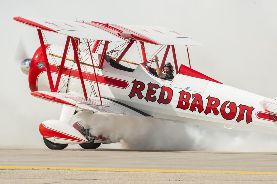 A Red Baron bi-plane pilot waves to the crowd as he finishes his act at the Northern Neighbors Day Air Show at Minot Air Force Base, N.D., Aug. 13, 2016. NND included several aerial acts including the F-16 Fighting Falcon, bi-plane crop dusters and old World War II planes. (U.S. Air Force photo/Airman 1st Class Christian Sullivan)
