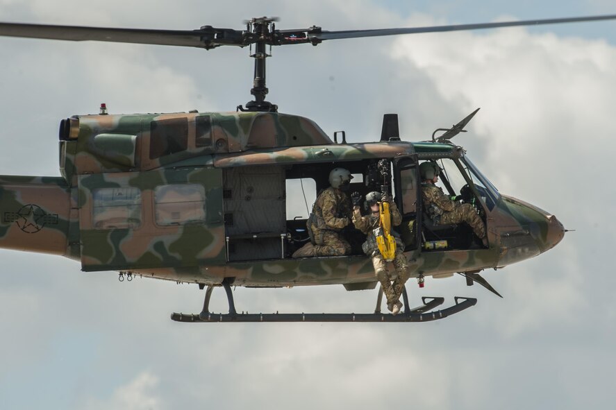 A 54th Helicopter Squadron member is hoisted up during a demonstration at the Northern Neighbors Day Air Show at Minot Air Force Base, N.D., Aug. 13, 2016. The 54th HS and the 91st Missile Security Force Squadron demonstrated the Huey’s ability to provide air to ground support. (U.S. Air Force photo/Airman 1st Class Christian Sullivan)