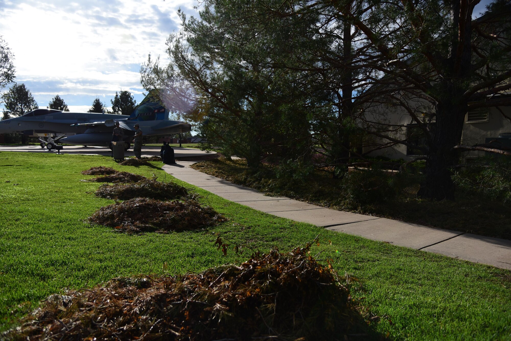 Senior Airman Joshua Ramos and Airman 1st Class Alexander Selchow, Colorado Springs Regional Command Post controllers, assist with the base clean up at the Peterson Air and Space Museum on Peterson Air Force Base, Colo., Aug. 10, 2016. Airman pitched in for base-wide clean-up and repairs after a hail storm struck the base. (U.S. Air Force photo by Staff Sgt. Amber Grimm) 