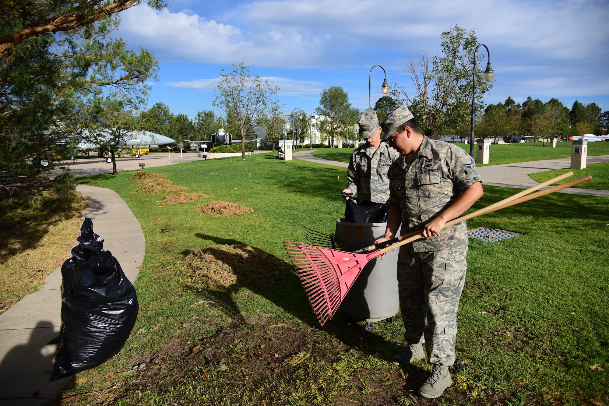 Senior Airman Joshua Ramos and Airman 1st Class Alexander Selchow, Colorado Springs Regional Command Post controllers, assist with the base clean up at the Peterson Air and Space Museum on Peterson Air Force Base, Colo., Aug. 10, 2016. Airman pitched in for base-wide clean-up and repairs after a hail storm struck the base. (U.S. Air Force photo by Staff Sgt. Amber Grimm) 
