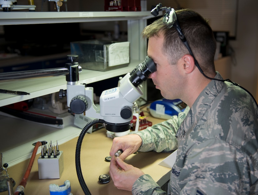Tech. Sgt. Louis Lough, 628th Medical Group noncommissioned officer in charge of the dental laboratory, uses a dental microscope to work on a bridge August 9, 2016, at Joint Base Charleston, S.C. Lough entered the Air Force in 2005 with no college education. He completed undergraduate and graduate degrees, and then earned a Doctorate of Business Administration while serving on active duty. (U.S. Air Force photo/Airman 1st Class Kevin West)