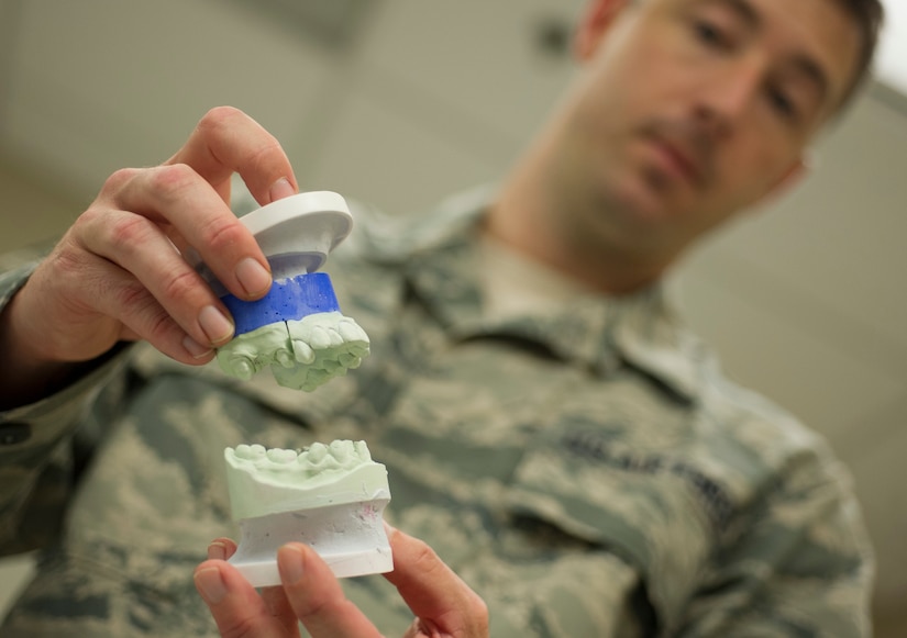 Tech. Sgt. Louis Lough, 628th Medical Group noncommissioned officer in charge of the dental laboratory, holds a cast teeth dental impression August 9, 2016, at Joint Base Charleston, S.C. Lough entered the Air Force in 2005 with no college education. He completed undergraduate and graduate degrees, and then earned a Doctorate of Business Administration while serving on active duty. (U.S. Air Force photo/Airman 1st Class Kevin West)
