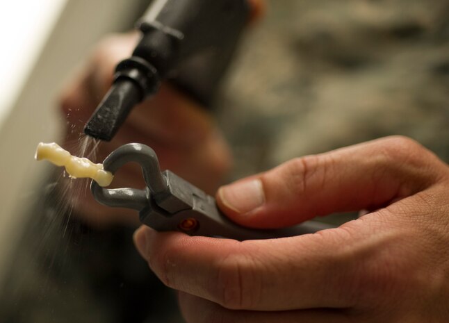 Tech. Sgt. Louis Lough, 628th Medical Group noncommissioned officer in charge of the dental laboratory, uses a steamer to clean a bridge August 9, 2016, at Joint Base Charleston, S.C. Lough entered the Air Force in 2005 with no college education. He completed undergraduate and graduate degrees, and then earned a Doctorate of Business Administration while serving on active duty. (U.S. Air Force photo/Airman 1st Class Kevin West)