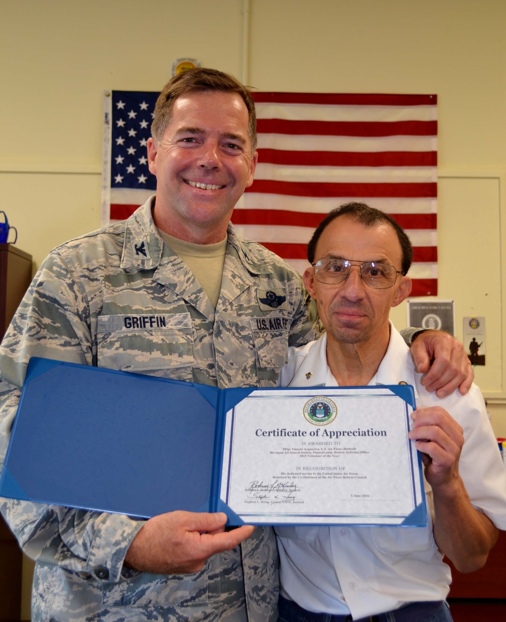 Col. William Griffin, the 111th Attack Wing vice commander, stands with retired Master Sgt. Vince Aquaviva, Horsham Air Guard Station Retire Activities Office (RAO) co-director, while displaying Aquaviva’s certificate for the RAO Volunteer of the Year, Horsham Air Guard Station, Pa., Aug.  13, 2016. The retired master sergeant served in the military for a total of 41 years and began volunteering at Horsham AGS’s RAO in March 2013. (U.S. Air National Guard photo by Tech. Sgt. Andria Allmond)