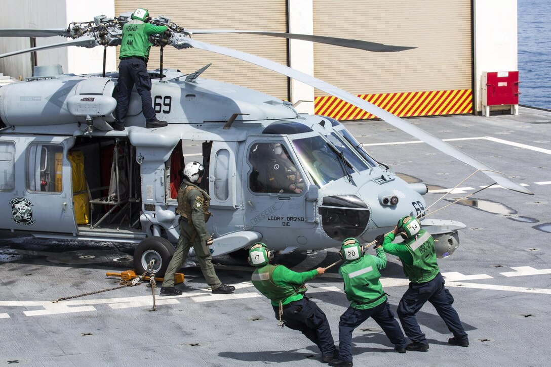 Sailors prepare an MH-60S Seahawk helicopter for a search and rescue exercise during Pacific Partnership 2016 in the Pacific Ocean, Aug. 14, 2016. During the exercise, personnel worked together to respond to a simulated maritime distress call resulting from a typhoon. Australian air force photo by Cpl. David Cotton